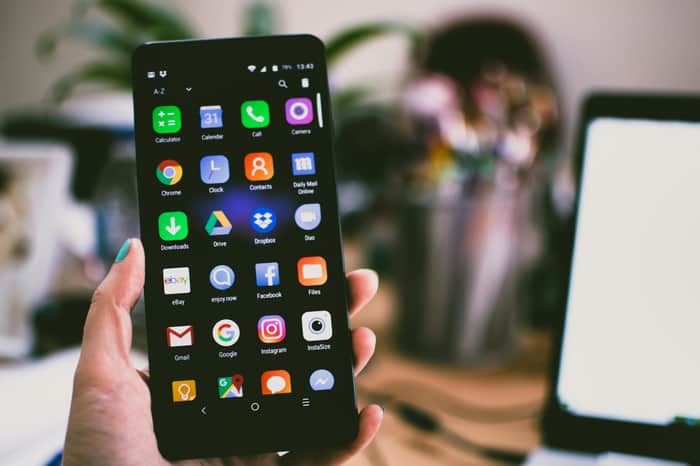 Foto dengan Fokus Selektif pada Seseorang yang Memegang Smartphone yang Menyala