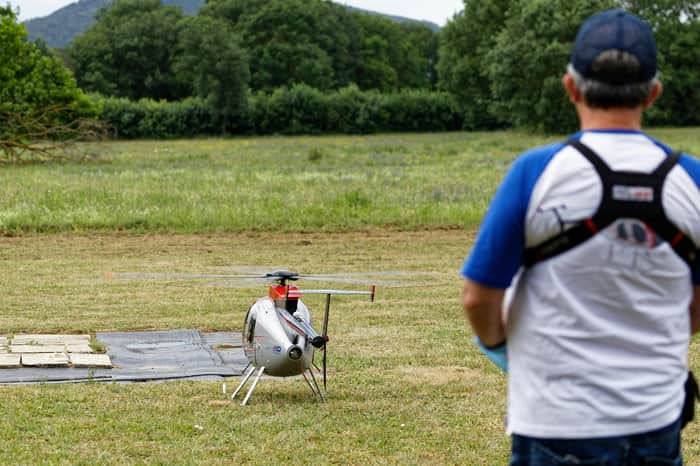 Seorang pria sedang menerbangkan mainan helikopter